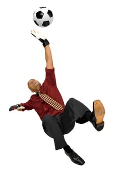 Businessman goalkeeper with gloves and ball in a acrobatic save isolated in white