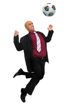 Businessman in a acrobatic pose with a soccer ball isolated in white