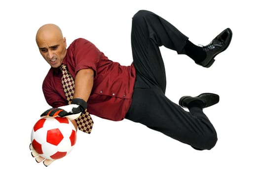 Businessman goalkeeper with gloves and ball in a acrobatic save isolated in white