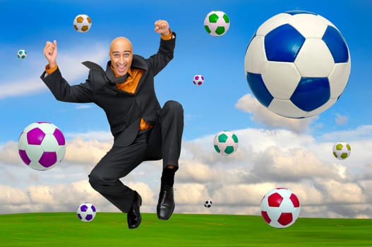 Businessman playing soccer outdoors in a green field