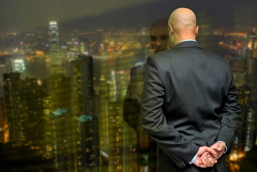 Businessman looking through a window to the city lights