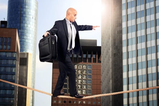 Businessman walking a rope in despair