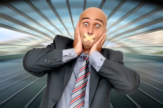 Distressed businessman with hands in his head and mouth covered with band aid