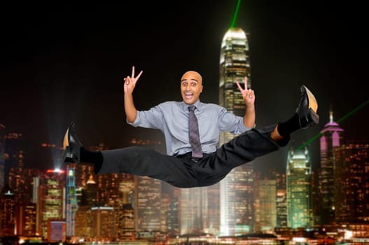 Happy businessman jumping high with a cityscape as background