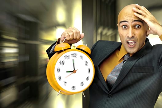 Businessman holding a big alarm clock