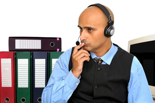 Thinking businessman with headset in the office isolated in white