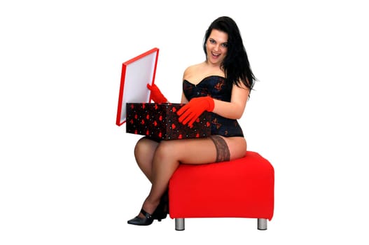 Surprised sexy woman opening a box in a red seat isolated in white