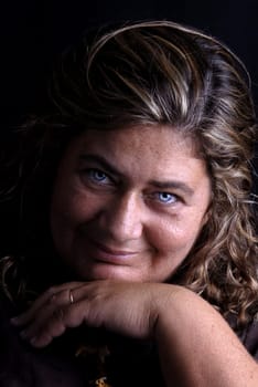 Beautiful blue eyed woman posing against a black background