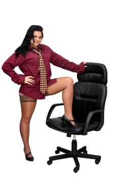 Sexy businesswoman in a chair with tie and stockings isolated in white