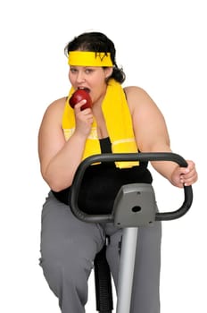Large girl with fitness bicycle holding an apple isolated in white