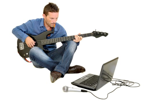 Young man playing guitar with a laptop