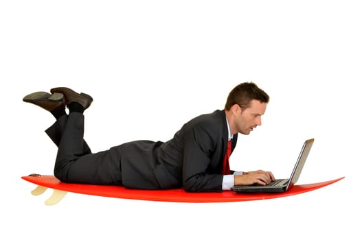 Young businessman laying in a surf board with laptop
