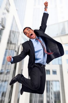 Happy businessman jumping outdoors