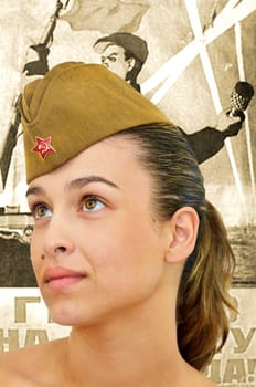 Sexy young girl with army hat with a ww II poster