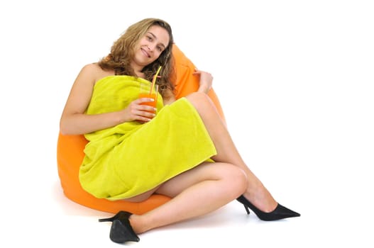 Sexy young girl with a natural juice glass and colorful towel isolated in white