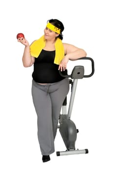 Large girl with a fitness bicycle and an apple
