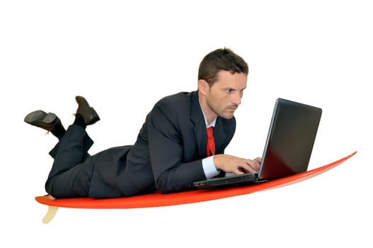 Young businessman laying in a surf board with laptop