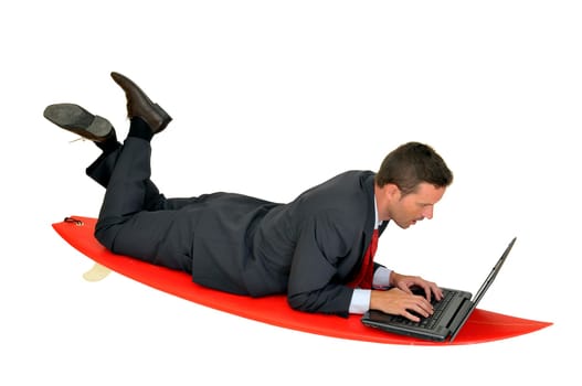 Young businessman laying in a surf board with laptop