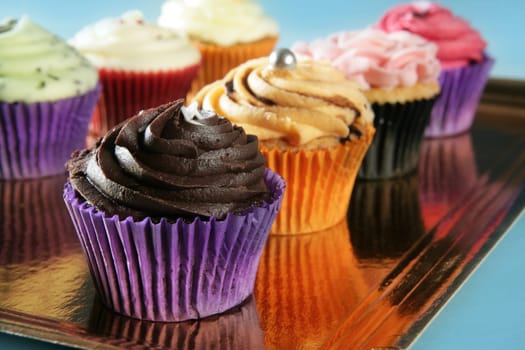 Cupcakes colorful cream muffin arrangement in golden mirror tray