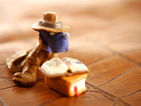 student plasticine handmade dog reading a book over brown background