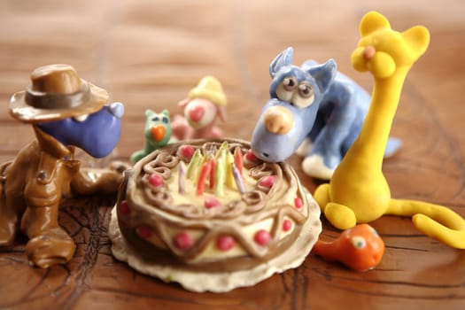 Toy plasticine happy birthday cake isolated over white background
