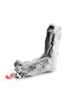 Toy plasticine statue replica feet treading an oil paint tube