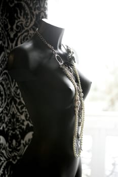 Black mannequin in backlit at natural light wearing nice jewelry