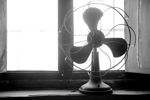 Antique vintage air fan in the window backlight