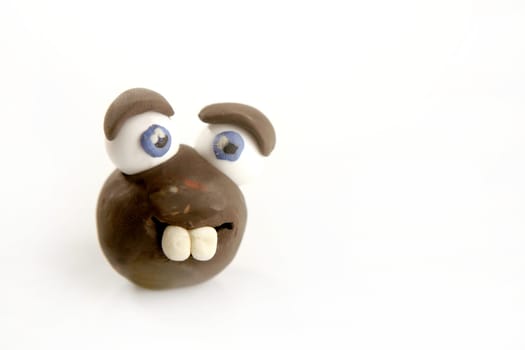Funny toy face plasticine handmade, big teeth and eyes on white