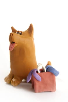 orange plasticine dog goes shopping with bag, isolated on white