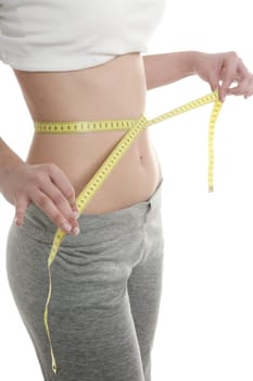 Beautiful in shape woman with yellow tape meter, white background