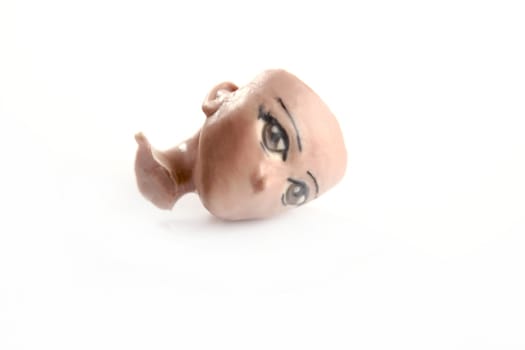 Handmade plasticine sculpture broken face replica isolated on white