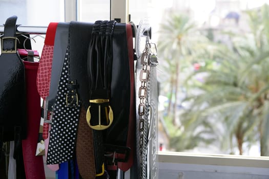 Rack of clothes with fashion accesories, woman design belts