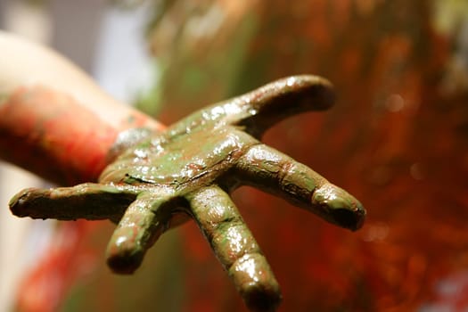 Children artist hands painting multi color with her fingers