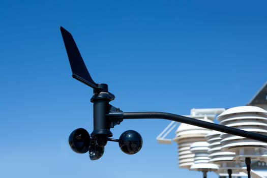 anemometer vane in weather station under blue sky