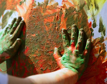 Children artist hands painting multi color with her fingers
