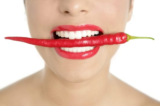 Beautiful woman teeth eating red hot chili pepper