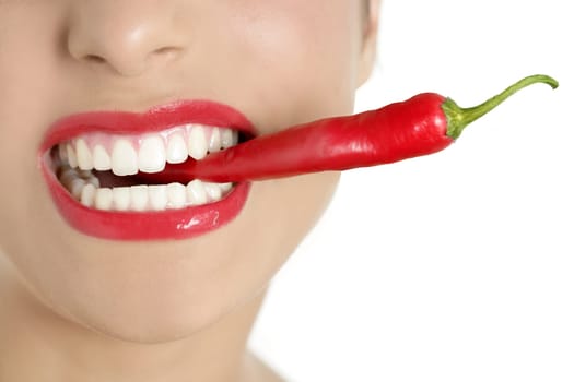 Beautiful woman teeth eating red hot chili pepper