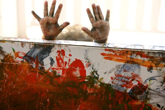 Children artist hands painting multi color with her fingers