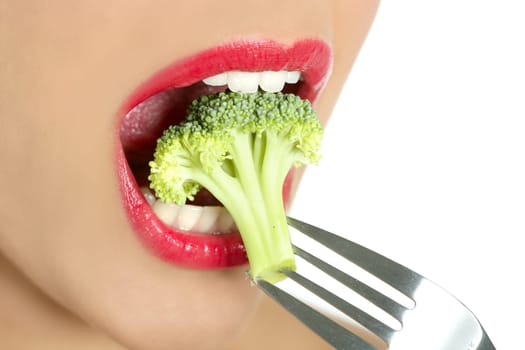 Broccoli on steel fork in woman mouth with red lips