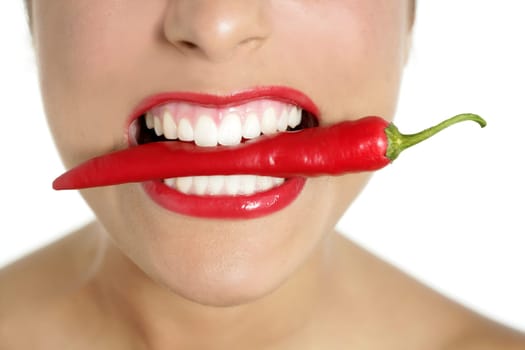 Beautiful woman teeth eating red hot chili pepper