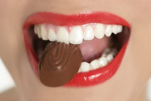 Chocolate sweet in beautiful woman mouth macro