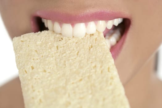 Biscuit in woman teeth and mouth having a healthy snack