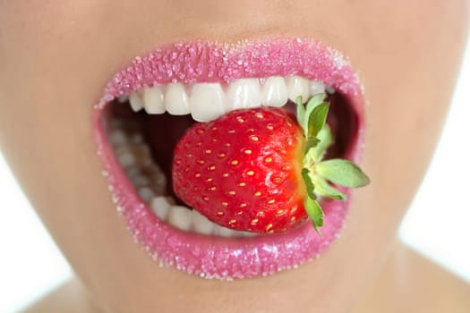Delicious strawberry fruit in pink woman mouth and teeth
