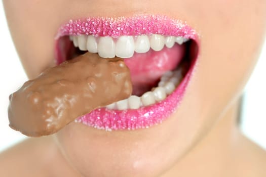 Chocolate sweet in beautiful woman mouth macro