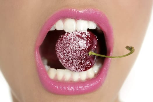 Cherry with sugar between woman perfect teeth macro