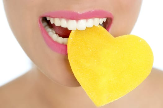 Heart shape candy on beautiful woman macro mouth
