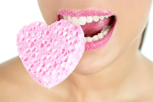 Heart shape makeup sponge on beautiful woman macro mouth