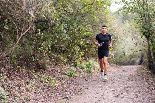 man practicing trail running in the forest, concept of sport in nature and healthy lifestyle, copy space for text