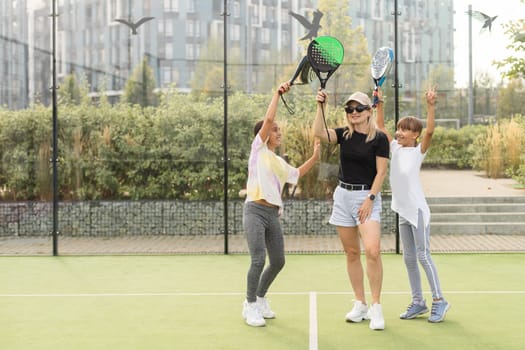 mother and daughters playing padel outdoor. High quality photo